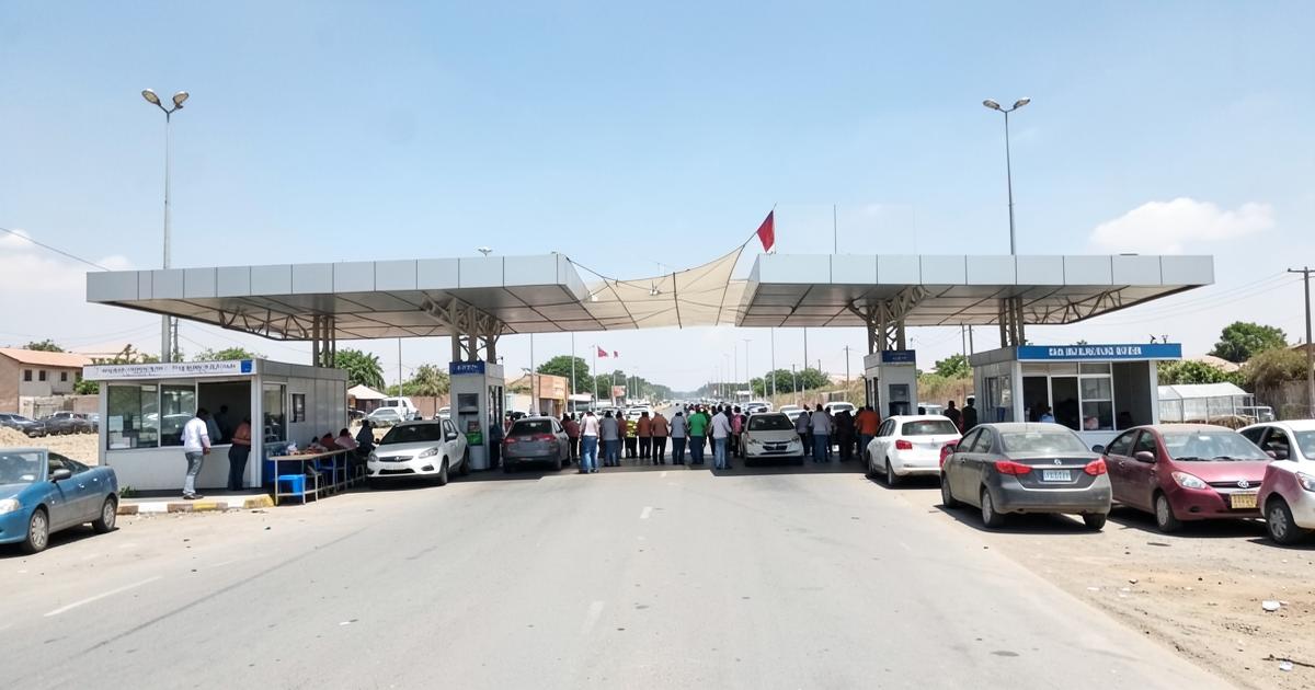 Vehicles queuing at booths at a land border crossing checkpoint